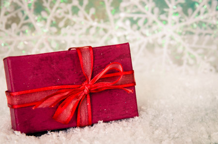 shining red christmas box with surprise inside in golden backgroundの写真素材