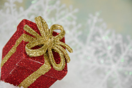shining red christmas box with surprise inside in golden backgroundの写真素材