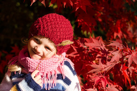 portrait of smiling girl in colorful autumnal atmosphereの写真素材