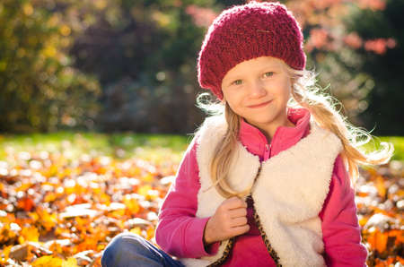 portrait of smiling girl in colorful autumnal atmosphereの写真素材