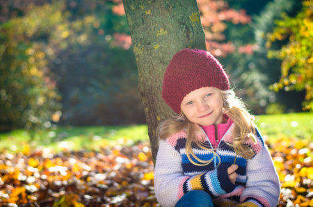portrait of smiling girl in colorful autumnal atmosphereの写真素材