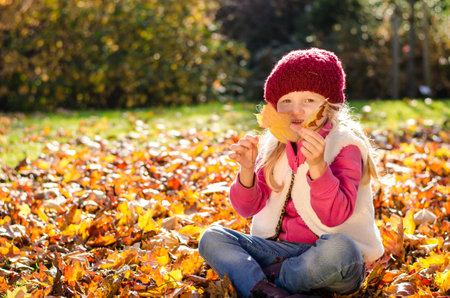 portrait of smiling girl in colorful autumnal atmosphereの写真素材