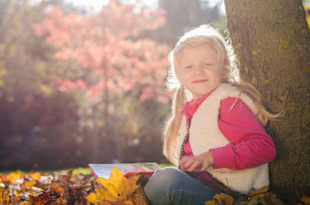 portrait of smiling girl in colorful autumnal atmosphereの写真素材