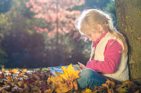 portrait of smiling girl in colorful autumnal atmosphereの写真素材