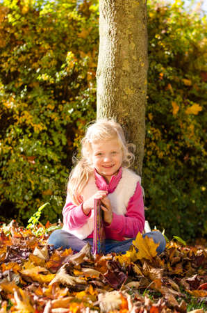 portrait of smiling girl in colorful autumnal atmosphereの写真素材