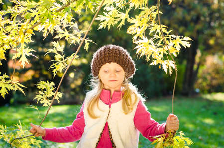 portrait of smiling girl in colorful autumnal atmosphereの写真素材