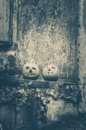 two orange carved halloween pumpkins in front of the house monochromeの写真素材