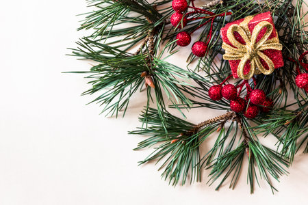 simple christmas tree with pine branch and red decorations on red backgroundの写真素材