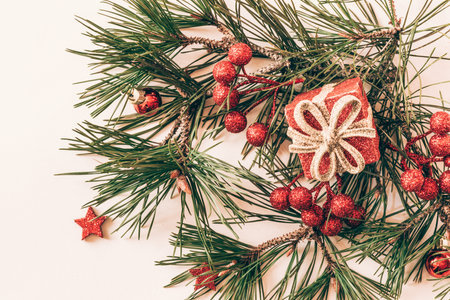 simple christmas tree with pine branch and red decorations on red backgroundの写真素材