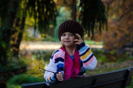 portrait of happy smiling girl with long blond hair in colorful autumnal atmosphere posing in green...