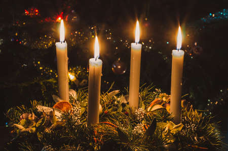 one burning candle concept with shining bokeh glittering ligts on christmas tree on dark backgroundの写真素材