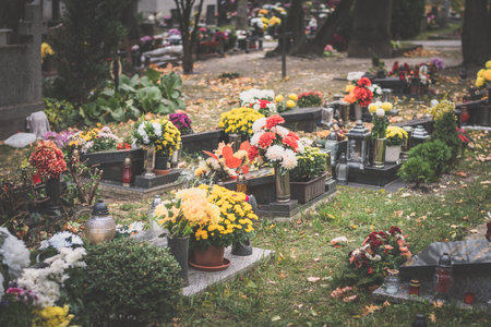 burning candle and chrysanthemum flower decoration on grave in the cemetery