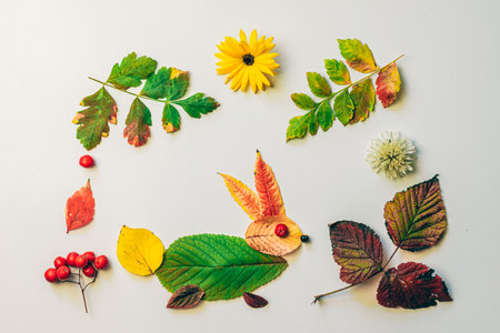 romantic woman face with natural hair made from colorful leaves and bright flowers on white backgroundの写真素材