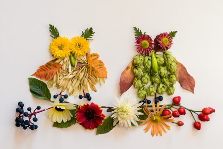 romantic woman face with natural hair made from colorful leaves and bright flowers on white backgroundの写真素材