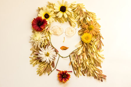 romantic woman face with natural hair made from colorful leaves and bright flowers on white backgroundの写真素材