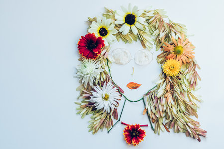 cute figures, dancers made from colorful leaves and bright flowers on white backgroundの写真素材