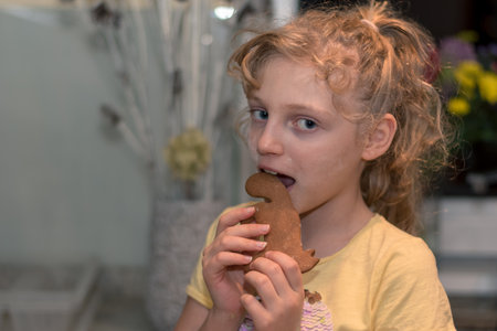 lovely child girl tasting and enjoying sweet color paste while cooking gingerbread cookies for christmas tableの写真素材