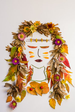 cat made from vivid autumnal leaves and flowers, isolated on white backgroundの写真素材