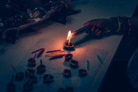 European christmas tradition, hand with fire and candle preparing nutshells with candles for water surfaceの写真素材