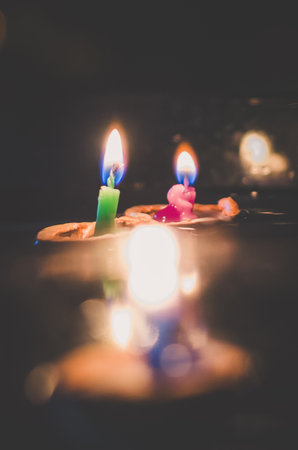 nutshell with burning candles floating on water surface in dark, European christmas traditionの写真素材
