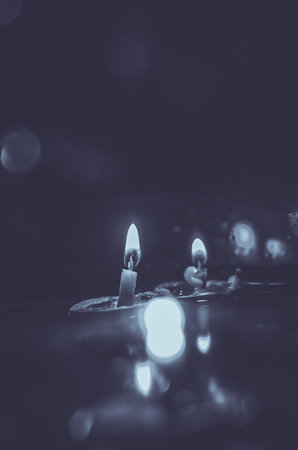 nutshell with burning candles floating on water surface in dark, European christmas traditionの写真素材