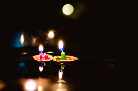 nutshell with burning candles floating on water surface in dark, European christmas traditionの写真素材