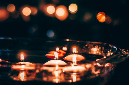 burning candles floating on water surface in dark, European christmas traditionの写真素材