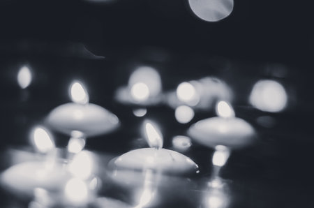 burning candles floating on water surface in dark, European christmas traditionの写真素材