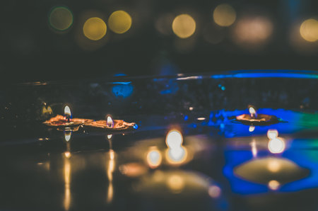 nutshell with burning candles floating on water surface in dark, European christmas traditionの写真素材