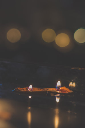 nutshell with burning candles floating on water surface in dark, European christmas traditionの写真素材
