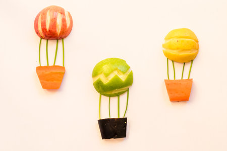 flying balloon made from apples and carrots, isolated colorful food ideasの写真素材