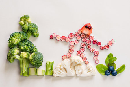 octopus made from red fruits with sea world from cauliflower, broccoli and green herbs isolated on white backgroundの写真素材