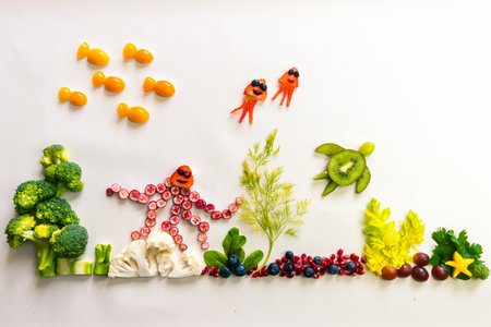 octopus made from red fruits, fish from orange tomato, jellyfish from strawberry, turtle from kiwi in sea world from cauliflower, broccoli and green herbs isolated on white backgroundの写真素材