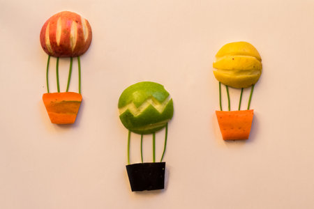 flying balloon made from apples and carrots, isolated colorful food ideasの写真素材