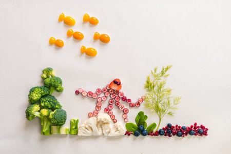 octopus made from red fruits, fish from orange tomato with sea world from cauliflower, broccoli and green herbs isolated on white backgroundの写真素材