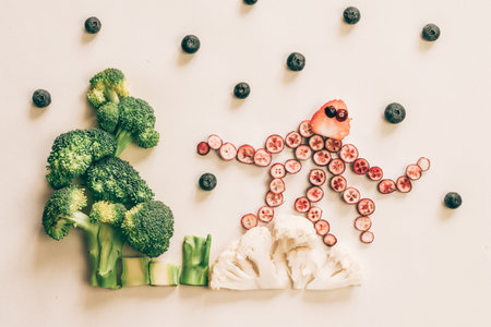 octopus made from red fruits with sea world from cauliflower, broccoli and green herbs isolated on white backgroundの写真素材