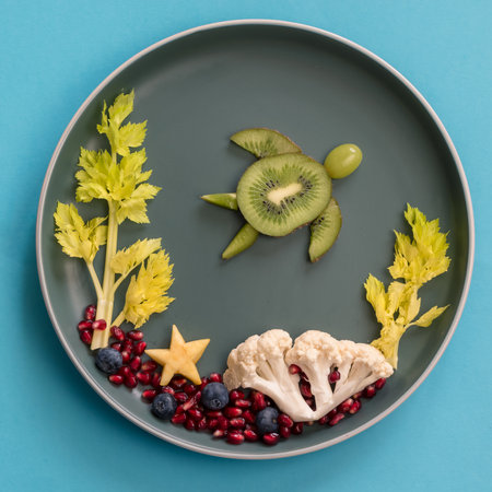 turtle, corals and plants in sea world from blackberries, kiwi, salad and cauliflower, isolated colorful food ideas on plate, copy spaceの写真素材