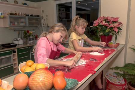 children preparing christmas gingerbread in the kitchenの写真素材
