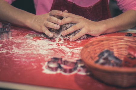 children preparing christmas gingerbread in the kitchen, festive atmosphereの写真素材