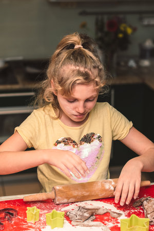 children preparing christmas gingerbread in the kitchen, festive atmosphereの写真素材