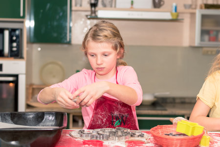 children preparing christmas gingerbread in the kitchen, festive atmosphereの写真素材