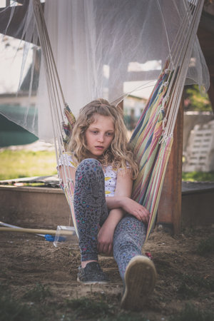 child relaxing in hammock swing in the gardenの写真素材