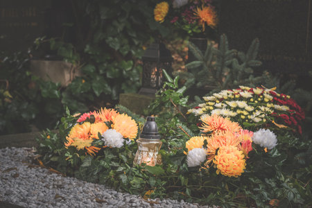 graves decorated with lanterns, burning candles, colorful chrysanthemum flowers, catholic symbolsの写真素材