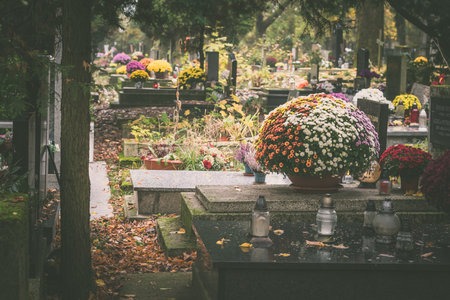 graves decorated with lanterns, burning candles, colorful chrysanthemum flowers, catholic symbolsの写真素材
