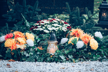 graves decorated with lanterns, burning candles, colorful chrysanthemum flowers, catholic symbolsの写真素材