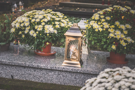 graves decorated with lanterns, burning candles, colorful chrysanthemum flowers, catholic symbolsの写真素材