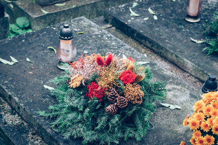 graves decorated with lanterns, burning candles, colorful chrysanthemum flowers