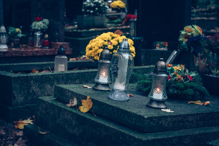 graves decorated with lanterns, burning candles, colorful chrysanthemum flowers, catholic symbolsの写真素材