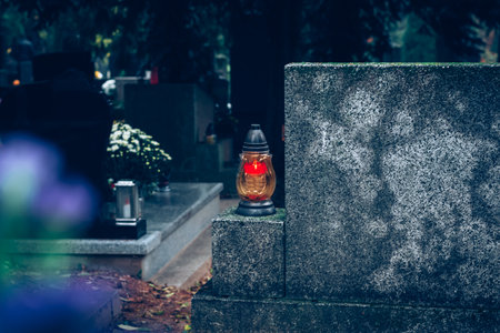 graves decorated with lanterns, burning candles, colorful chrysanthemum flowers, catholic symbols