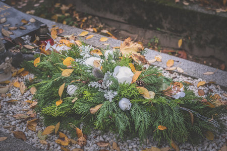 graves decorated with burning candles, colorful chrysanthemum flowers, catholic symbols
